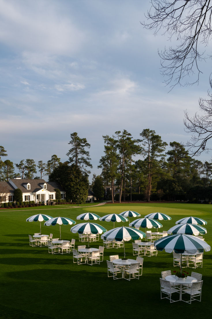 a lawn with umbrellas and tables
